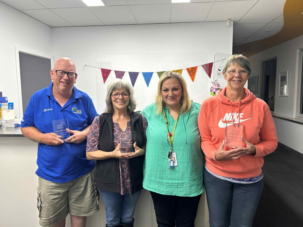 Three Substance Abuse Support Peer Leads holding awards with Team Leader